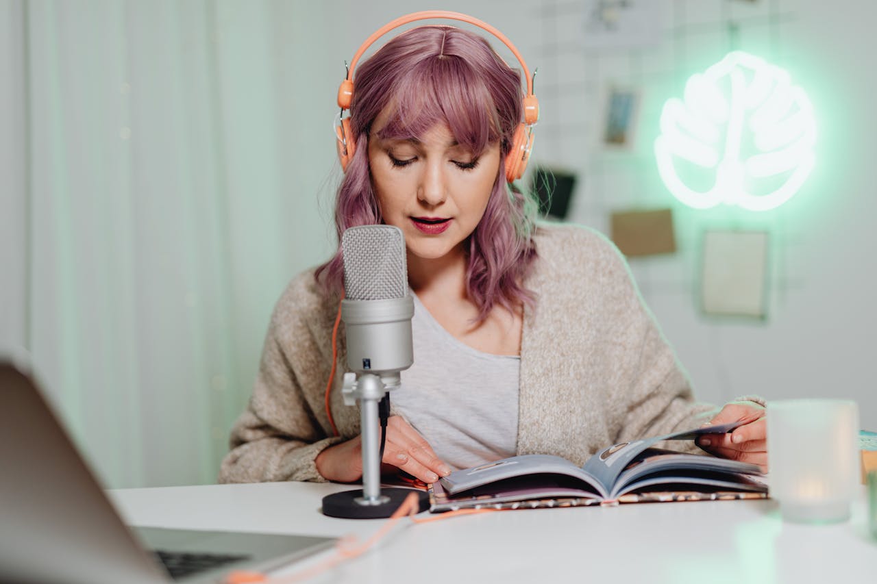 Casual indoor podcast recording featuring a woman with headphones reading from a book.